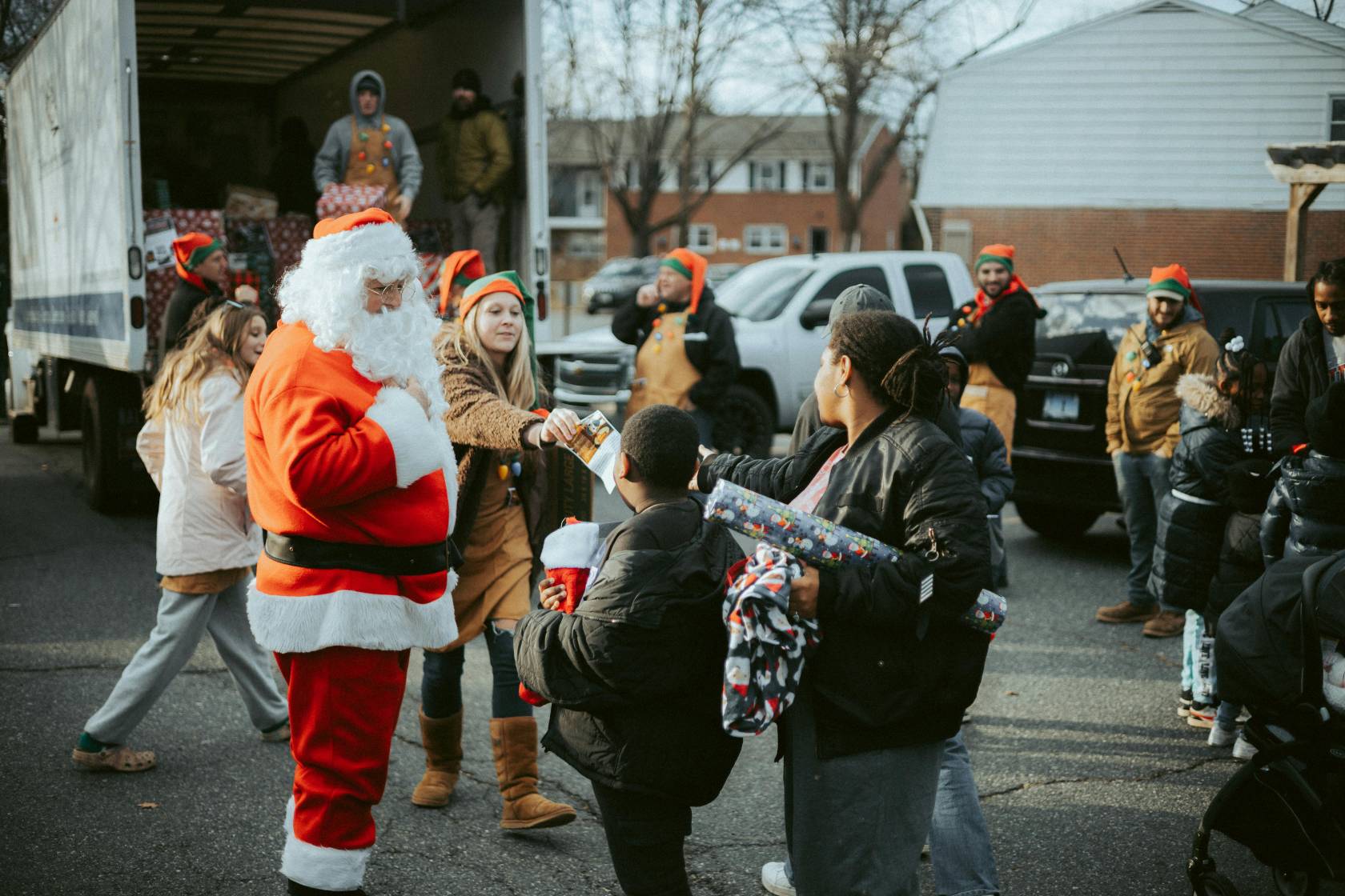 Bearded man in Santa Claus jacket and winter boots holding 1-9118 sign.